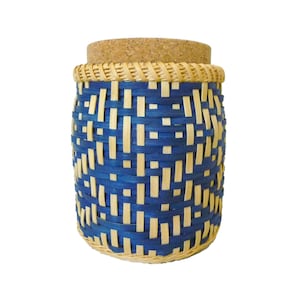 May include: A blue and natural woven bamboo storage jar with a cork lid. The jar has a woven pattern with blue and natural colored bamboo.