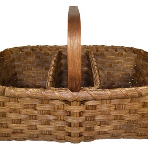 May include: A brown wicker basket with a wooden handle and three divided sections. The basket is woven with a tight, even pattern.