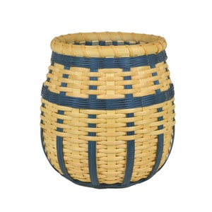 May include: A woven basket with a light brown base and dark blue accents. The basket is round and has a wide opening.