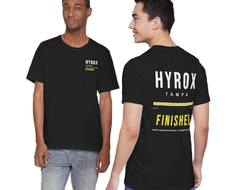 May include: A black short-sleeve t-shirt featuring a small white and yellow Hyrox Tampa Finisher logo on the chest and a large graphic on the back with the text Hyrox Tampa, a yellow bar, and the word Finisher in bold yellow letters.