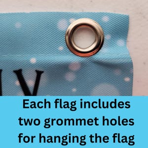 May include: Close-up of a blue fabric flag with white polka dots. The flag has a silver grommet hole in the top corner. Each flag includes two grommet holes for hanging the flag.