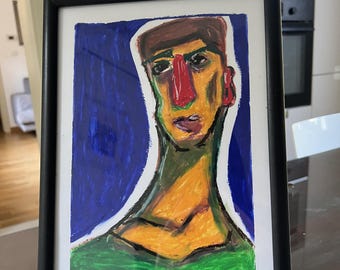 Puede incluir: Un dibujo de retrato enmarcado que muestra una figura estilizada con una nariz roja prominente, cabello castaño y una camisa verde sobre un fondo azul intenso. La obra está en un marco negro sencillo e incluye el texto Ernesto y una firma.