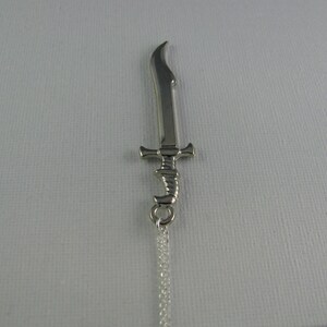 May include: A silver sword pendant necklace with a detailed design. The sword has a curved blade and a decorative handle.