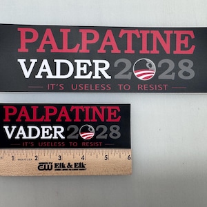 May include: Two black and white political campaign stickers with red text. The stickers feature the text "Palpatine Vader 2028" and the slogan "It's useless to resist".
