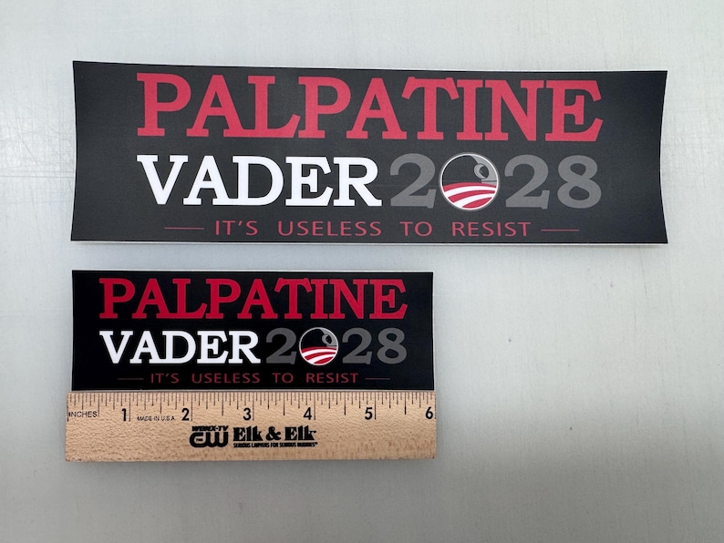 May include: Two black and white political campaign stickers with red text. The stickers feature the text "Palpatine Vader 2028" and the slogan "It's useless to resist".