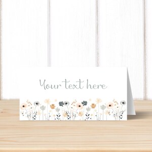 May include: A white card with a border of light blue, beige, and white flowers. The text "Your text here" is written in light blue on the card.