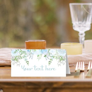 May include: A white place card with a blue and white floral design. The text "Your text here" is printed in blue on the card.