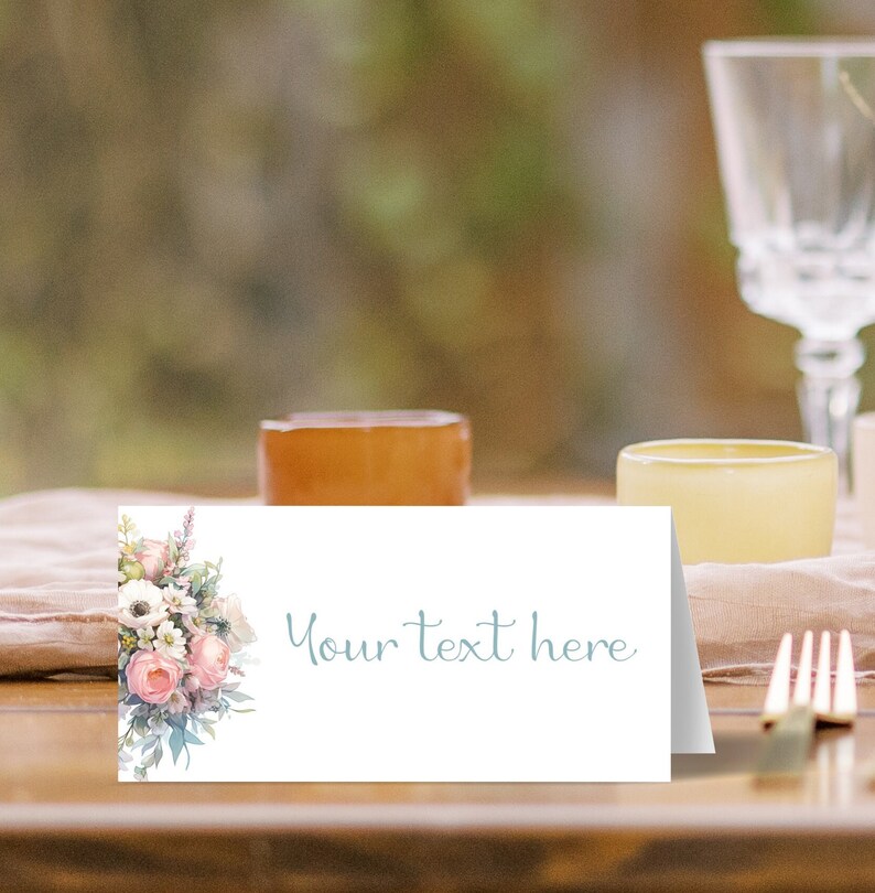May include: A white place card with a floral design on the left side. The text "Your text here" is printed in light blue on the right side.