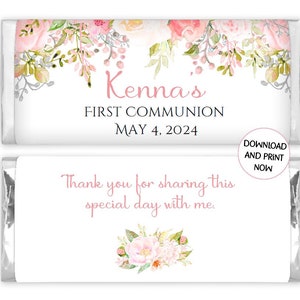 May include: A white chocolate bar wrapper with pink floral designs. The text "Kenna's First Communion May 4, 2024" is printed on the wrapper. The back of the wrapper says "Thank you for sharing this special day with me."