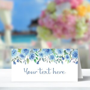 Pu&ograve; includere: Un segnaposto bianco con un bordo floreale blu ad acquerello e il testo "Your text here".