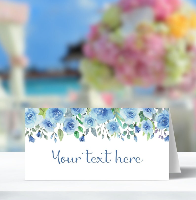 Pu&ograve; includere: Un segnaposto bianco con un bordo floreale blu ad acquerello e il testo "Your text here".