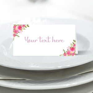May include: White place card with pink floral design and the text "Your text here" in pink.