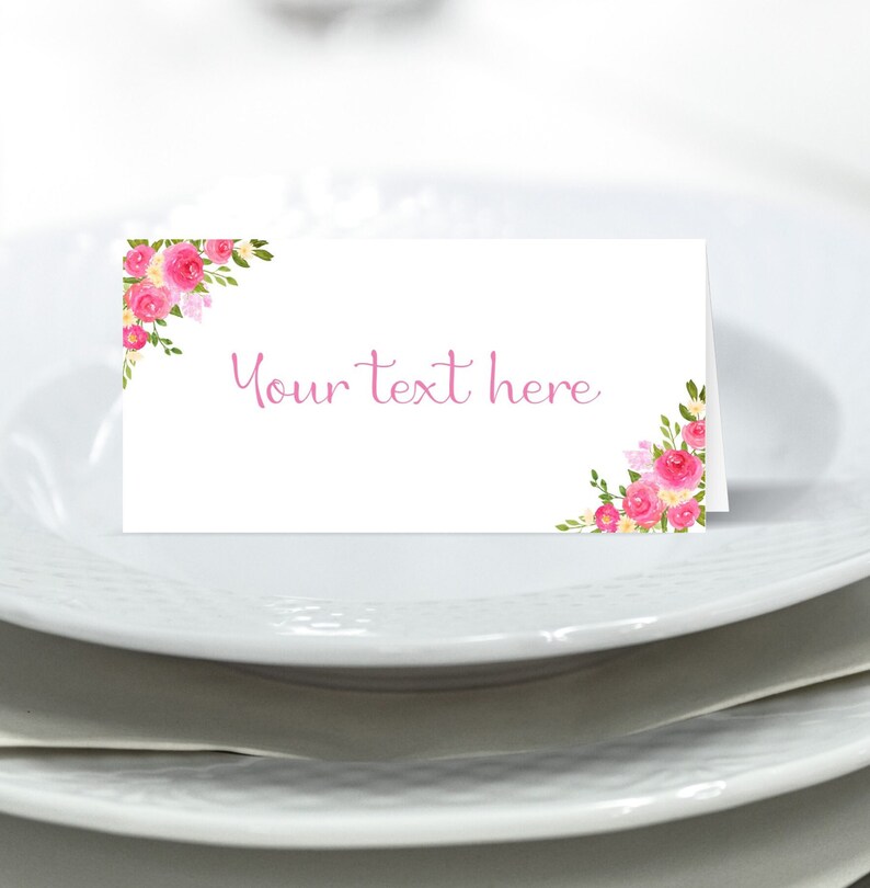 May include: White place card with pink floral design and the text "Your text here" in pink.
