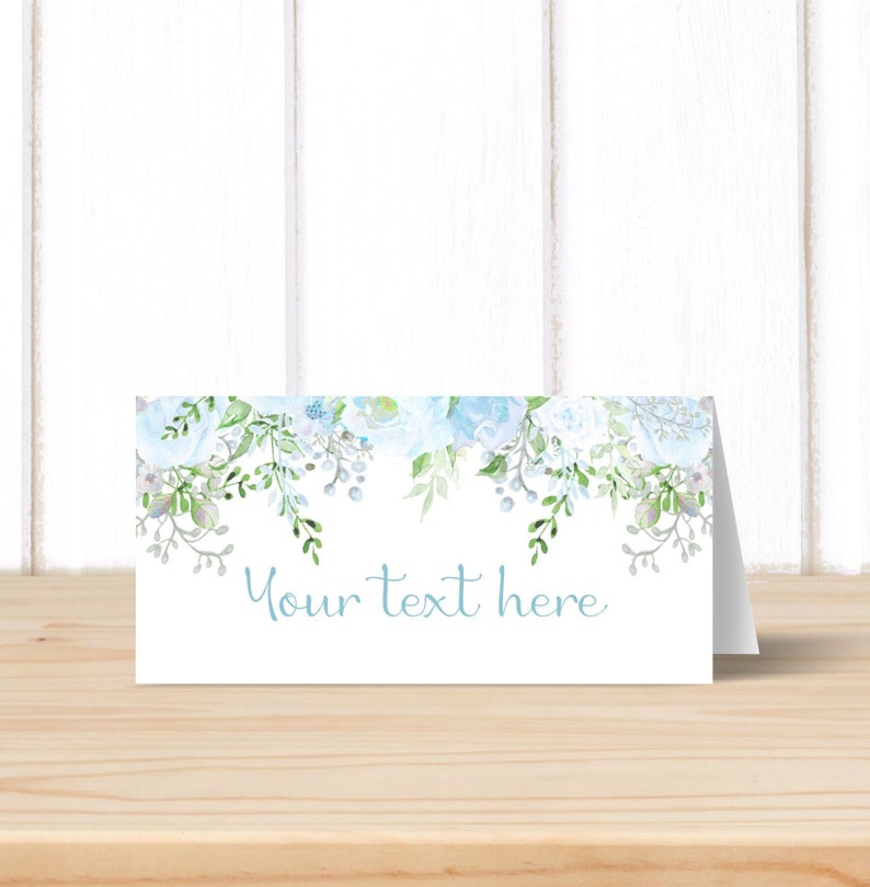 May include: White place card with a blue floral border and the text "Your text here" in blue.