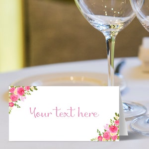 May include: White place card with pink floral design and the text "Your text here".