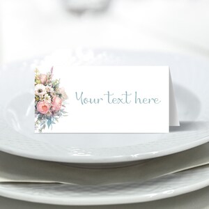 May include: White place card with a floral design on the left side and the text "Your text here" in blue on the right side.
