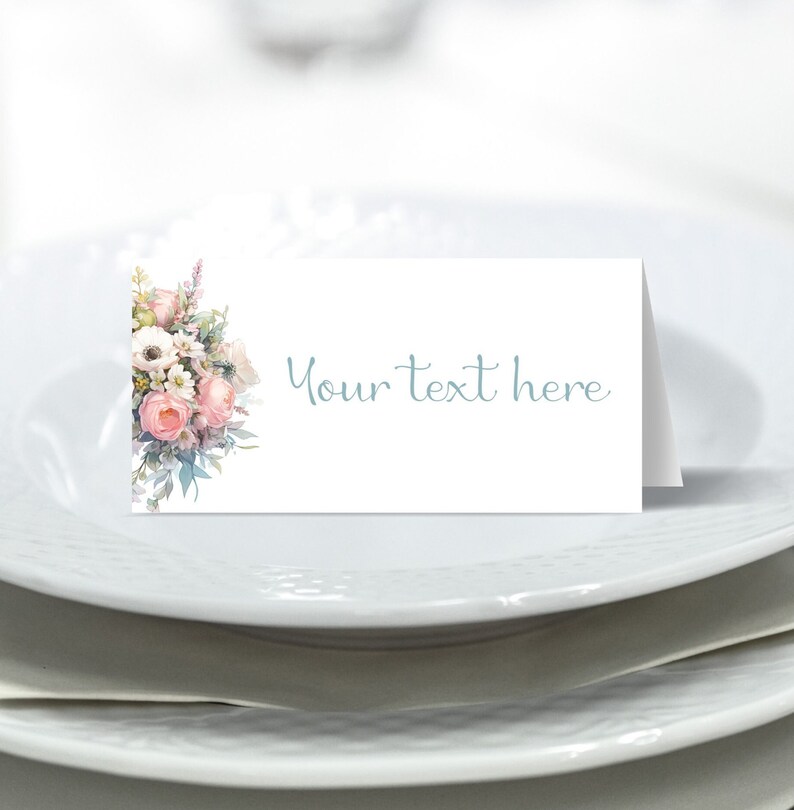 May include: White place card with a floral design on the left side and the text "Your text here" in blue on the right side.