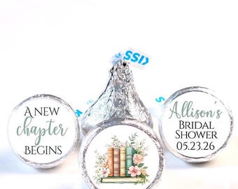 May include: Silver foil-wrapped chocolate candies with custom labels. One label reads "A New Chapter Begins" in script. Another features a stack of books with floral accents. The third label says "Allison's Bridal Shower 05.23.26".