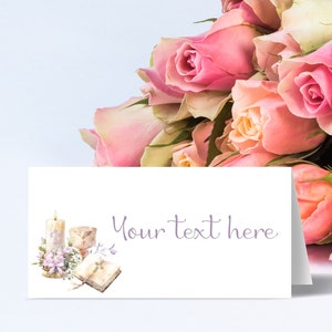 May include: A white card with a watercolor illustration of a candle, chalice, and open book. The text "Your text here" is printed in purple on the card. The card is surrounded by a bouquet of pink roses.