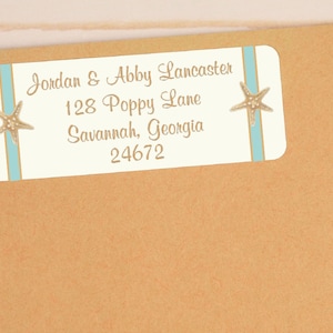 May include: White return address label with blue and gold stripes and gold starfish accents. The label reads "Jordan & Abby Lancaster, 128 Poppy Lane, Savannah, Georgia 24672".