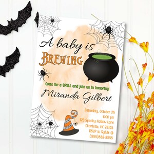 Può includere: Un invito a un baby shower a tema Halloween con un calderone nero pieno di liquido verde e un design a ragnatela. Il testo recita "A baby is BREWING Come for a SPELL and join us in honouring Miranda Gilbert Saturday, October 28 6:00 pm 123 Spooky Hallow Lane Charlotte, NC 28105 RSVP to Sylvie @ (888) 888-8888"