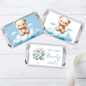 May include: Three blue and white favor labels for baby shower favors. One label features a teddy bear sitting on a cloud with the text "We can Bearly wait!" Another label features a teddy bear sitting on a cloud with blue and white balloons. The third label features a teddy bear sitting on a cloud.