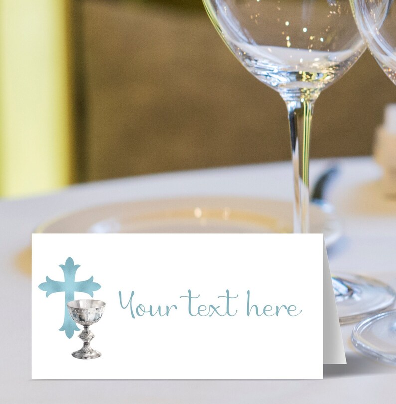 May include: A white place card with a blue watercolor cross and chalice design. The text "Your text here" is printed in blue.