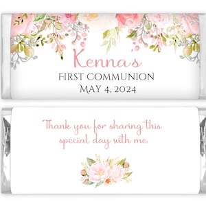 May include: A white chocolate bar wrapper with pink floral designs and the text "Kenna's First Communion May 4, 2024". The bottom of the wrapper has the text "Thank you for sharing this special day with me." and a pink floral design.