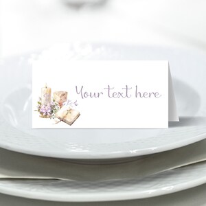 May include: White place card with a watercolor illustration of a candle, chalice, book, and flowers. The text "Your text here" is printed in purple.