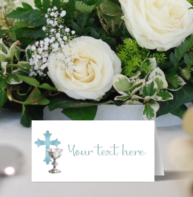 May include: A white card with a blue cross and chalice design. The text "Your text here" is written in blue cursive script.