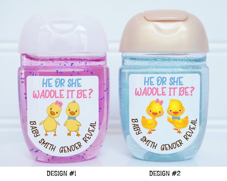 May include: Two clear plastic bottles with labels that say "He or She Waddle It Be?" and feature a cartoon image of a yellow duckling with a pink bow and a yellow duckling with a blue bow. The labels also say "Baby Smith Gender Reveal". The bottle on the left is pink and the bottle on the right is blue.