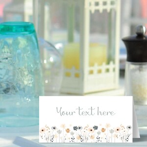 May include: A white place card with a gray floral border and the text "Your text here".