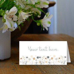May include: White card with a gray floral border and the text "Your text here" in gray. The card is on a wooden surface.