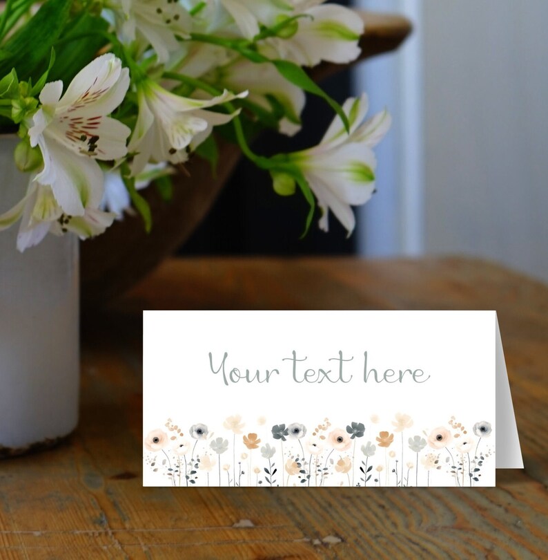 May include: White card with a gray floral border and the text "Your text here" in gray. The card is on a wooden surface.