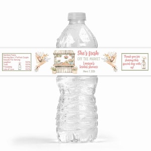 May include: A clear plastic water bottle with a custom label. The label features text that reads "She's fresh off the market, Lauren's bridal shower, March 7, 2026." The label also includes floral bouquets and a flower stand illustration.