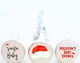 May include: Three round white labels with red and white Santa hats. The labels say "Santa Baby" and "Madison's Baby Shower".
