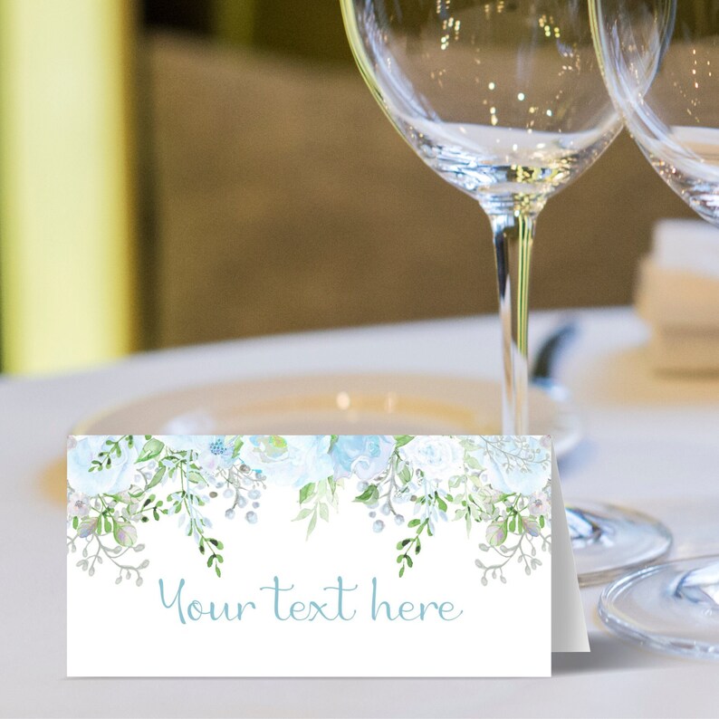 May include: White place card with a blue floral design and the text "Your text here".