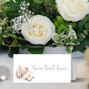 May include: White place card with a watercolor illustration of a candle, chalice, and open book. The text "Your text here" is printed in purple.