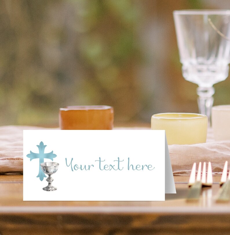 May include: A white place card with a blue cross and chalice design. The text "Your text here" is printed in blue on the card.