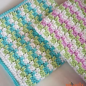 May include: Two crocheted baby blankets, one in shades of green, blue, and white, and the other in pink, green, and white.