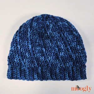 May include: A blue and dark blue crocheted beanie hat with a swirling pattern.