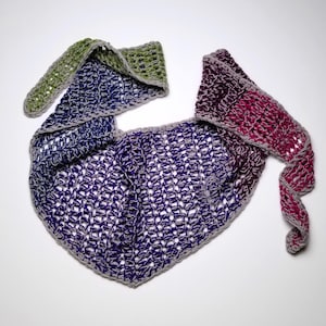 May include: A handmade crochet shawl in a triangular shape. The shawl features a gradient of colors, transitioning from green to blue to purple and then to pink. The edges are finished with a gray border.
