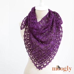 May include: A purple crochet shawl with a delicate lace pattern. The shawl is draped over a white mannequin.