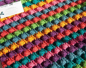 Schema all'uncinetto per copertina per neonati con pompon in formato PDF - Copertina per neonati a righe con insalata di more