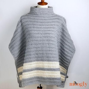 May include: Gray crochet poncho with a white stripe pattern. The poncho has a high neck and a loose fit.