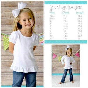 May include: A young girl wearing a white ruffle-hemmed shirt and blue jeans, with a large white bow in her hair. A size chart for girls' ruffle shirts is also visible. The shirt has short sleeves and a round neckline.