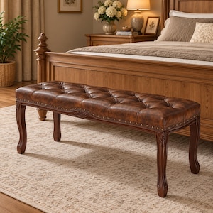 May include: A rectangular bench featuring a tufted brown leather seat with button detailing. The bench has a dark wood frame with curved legs and decorative nailhead trim along the edges of the seat base, providing a sturdy and structured furniture piece.
