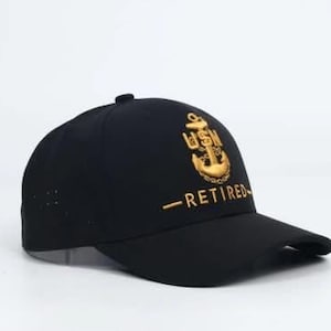 以下が含まれることがあります： 前面に金色の刺繍が施された黒い野球帽。デザインには、USNの錨のエンブレムと、その下に横線で挟まれた「RETIRED」という文字が含まれています。帽子は構造化されたクラウンと湾曲したつばを備えています。