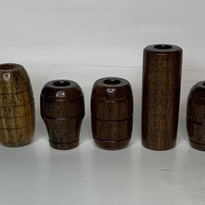 May include: Six wooden barrel-shaped knobs in various shades of brown. The knobs are all about 2 inches long and have a smooth, polished finish.