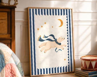 May include: A framed rectangular wall art print featuring a cream-coloured background with a dark blue striped border. The illustration depicts a white polar bear wearing a long blue scarf, floating among yellow stars and a crescent moon.